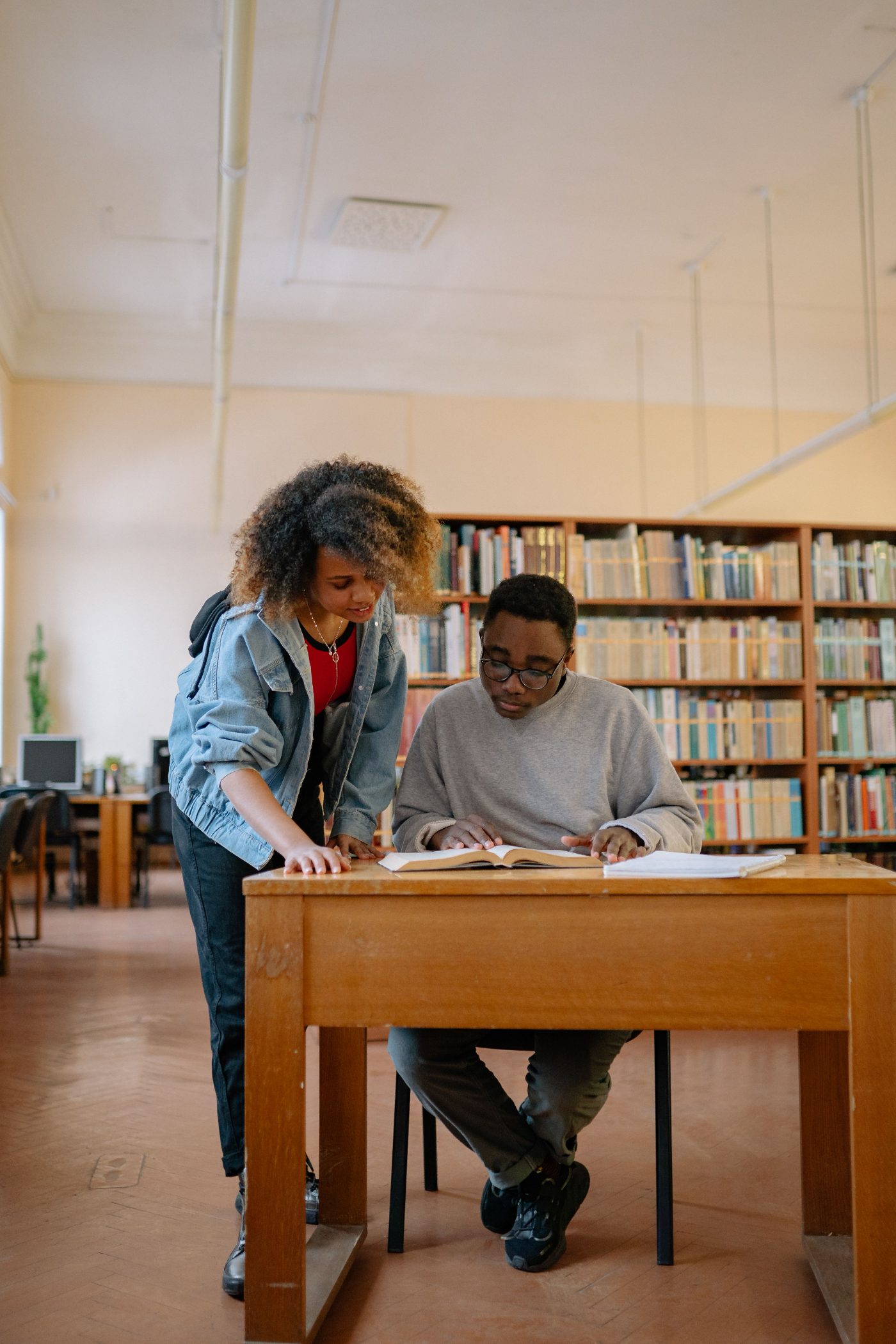 Two students studying together at a library desk
